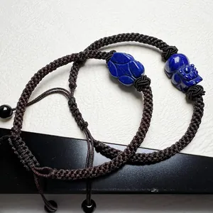 Detailed view of hand-woven Lapis Lazuli bracelets with PiXiu carving and adjustable cord