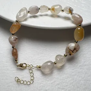 Detailaufnahme eines Natursteinarmbands mit Goldperlen und verstellbarem Verschluss