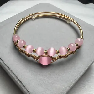 Detail of handmade 14K gold filled wire wrapped bracelet with pink cat eye stones