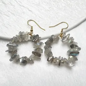 Dettaglio di orecchini dorati con cerchi di pietre di labradorite naturale irregolare