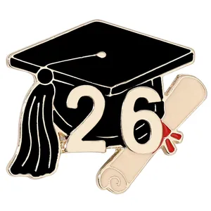 Detail view of 2026 graduation enamel brooch with mortarboard and diploma scroll
