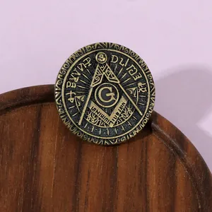 Macro shot of vintage bronze Masonic emblem badge with G symbol on a wooden base