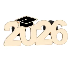 Detail of 2026 graduation pin with black bachelor cap and gold finish with rubber backs