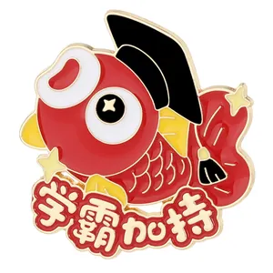 Macro detail of enamel koi fish pin with graduation cap and academic blessing text