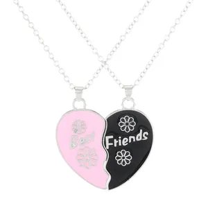 Matching Best Friends heart pendant necklaces with pink and black enamel floral design