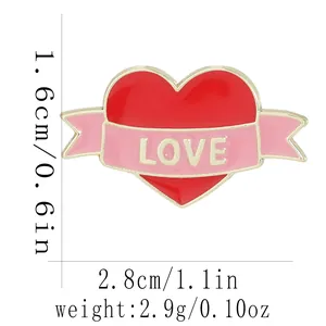 Détail du pin's cœur émaillé rouge avec ruban LOVE indiquant les dimensions 1,6x2,8cm