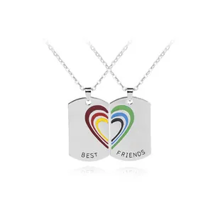 Close-up of split heart rainbow enamel dog tag necklaces engraved with BEST FRIENDS text