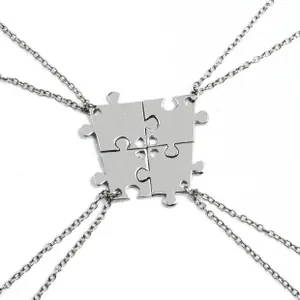 Detail of four-piece puzzle heart pendant necklaces set in polished silver finish