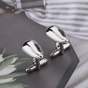 Polished silver teardrop cufflinks with bullet back closure on textured surface