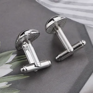 Macro shot of silver teardrop cufflinks with polished finish and non-slip texture detail