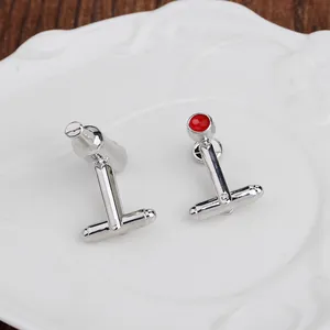 Dettaglio di gemelli da polso a forma di shaker argento e cristallo rosso da uomo