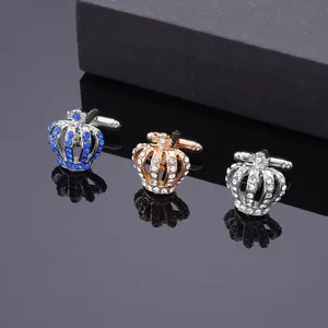 Dettaglio di eleganti gemelli a corona con strass in finiture argento e oro