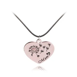 Close-up of heart-shaped rose gold pendant with Mom engraving and dandelion design