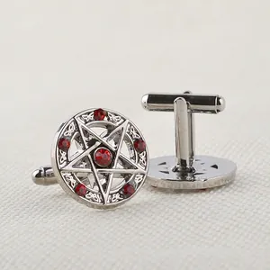 Dettaglio macro di gemelli da uomo a pentagramma con strass rossi e chiusura a scatto a T