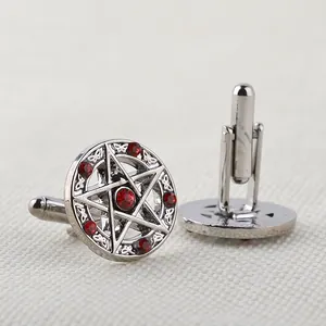 Dettaglio dei gemelli a stella in argento con strass rossi e chiusura a T