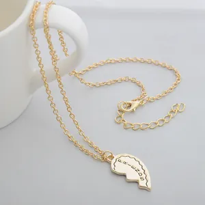 Detailed macro view of gold-tone Best Friends necklace with engraved heart pendant and O-chain