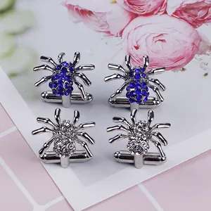 Detailopname van spinnen-manchetknopen met blauwe en heldere strass op bloemendisplay