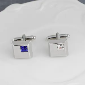 Dettaglio dei gemelli da uomo quadrati argentati con intarsio di cristalli blu e bianchi