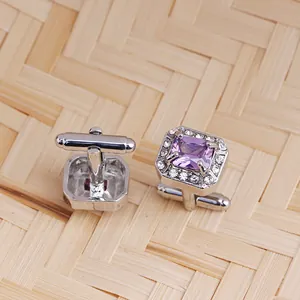 Détails de boutons de manchette argentés avec zircon violet et pavé de cristaux sur bambou