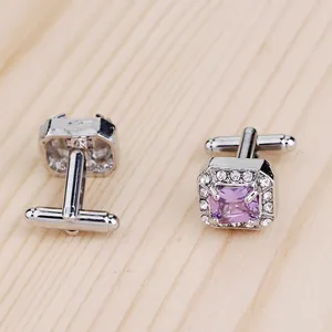 Détails des boutons de manchette argentés avec zircon violet et bordure en cristal