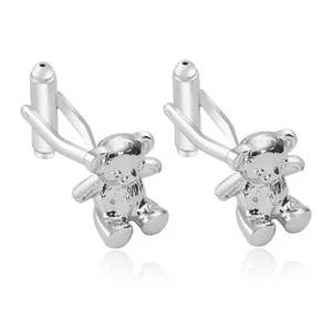 Dettaglio di gemelli a forma di orsetto in argento con zirconi e finitura lucida su sfondo bianco
