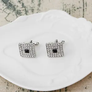 Dettaglio dei gemelli quadrati in argento con pietra nera centrale e piccoli cristalli
