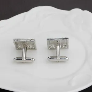 Detail of square silver cufflinks featuring classic bullet back closure and polished finish