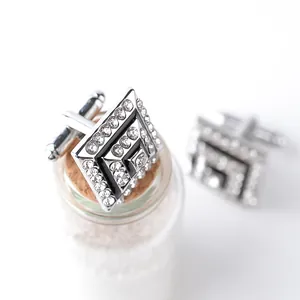 Macro shot of silver diamond-encrusted square cufflinks with black enamel center detail
