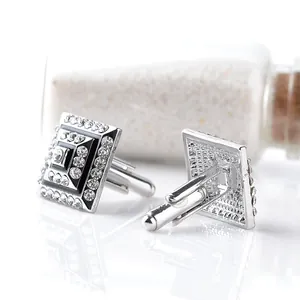 Macro view of square silver cufflinks with black enamel and sparkling white crystals