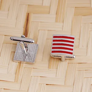 Square silver men's cufflinks with red stripes and T-bar closure on textured background