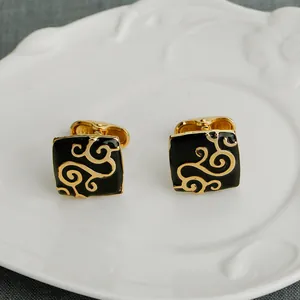 Boutons de manchette dorés avec motif floral et finition en émail noir