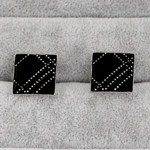 Detail of square cufflinks with black enamel panel and silver geometric dotted line patterns