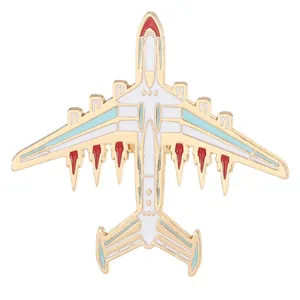 Airplane enamel pin in gold metal finish with white and red wings badge