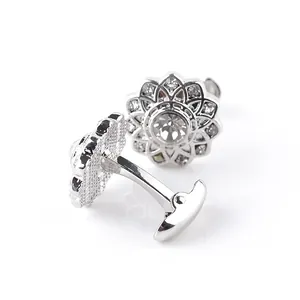 Macro shot of silver flower cufflinks with clear gemstone centers and sparkling petals