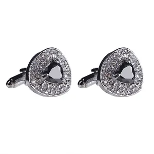 Close-up of heart-shaped cufflinks with black crystal and sparkling white rhinestones