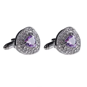 Detail of silver triangular cufflinks with purple gemstones and white crystal borders