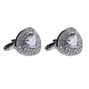 Close-up of silver triangular cufflinks with pavé-set crystals and bullet back closure