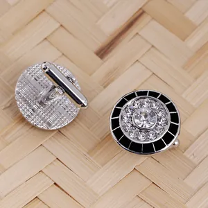Detailed macro view of silver round cufflinks with crystal rhinestones and black enamel finish