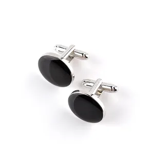 Detailed view of silver oval cufflinks with black onyx inlays and T-bar fastenings