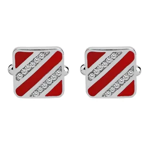 Détail de boutons de manchette carrés argentés avec émail rouge et strass brillants