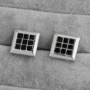 Boutons de manchette carrés noirs et argentés pour hommes sur plateau en velours gris