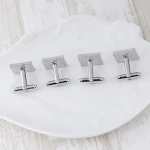 Detailed macro view of silver square cufflinks with T-shaped swivel bar back mechanisms