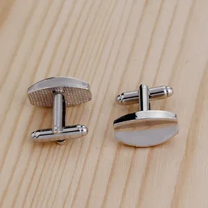 Close-up of silver geometric oval cufflinks with polished finish and T-bar fastening detail