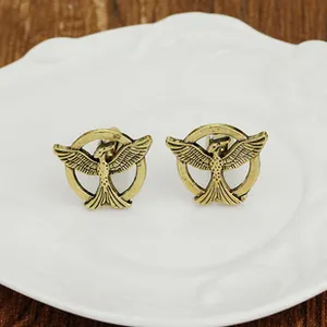 Makroaufnahme von Vintage-Vogel-Manschettenknöpfen auf einem Porzellanteller