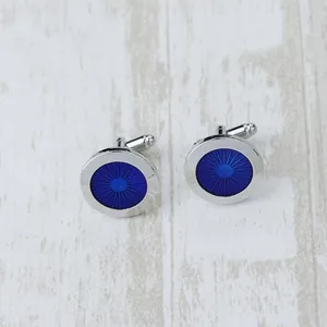 Macro detail of blue enamel cufflinks with radial patterns on a silver metal base