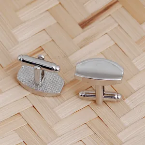 Polished silver geometric cufflinks for men with bullet back closure on bamboo mat