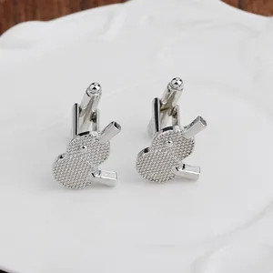 Macro view of silver table tennis paddle cufflinks with realistic textured rubber surface