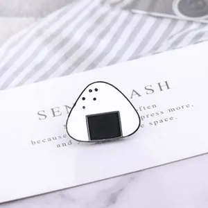 Detail of cute onigiri rice ball enamel pin on a white display card with marble background