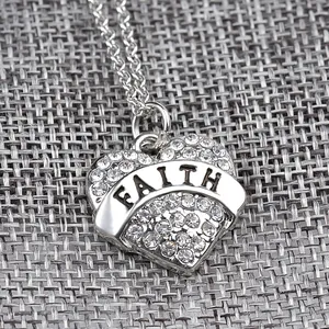 Dettaglio del ciondolo a cuore con incisione Faith e cristalli brillanti incastonati