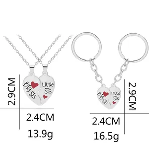 Detail view of silver Big Sis and Little Sis split heart necklaces and keychains